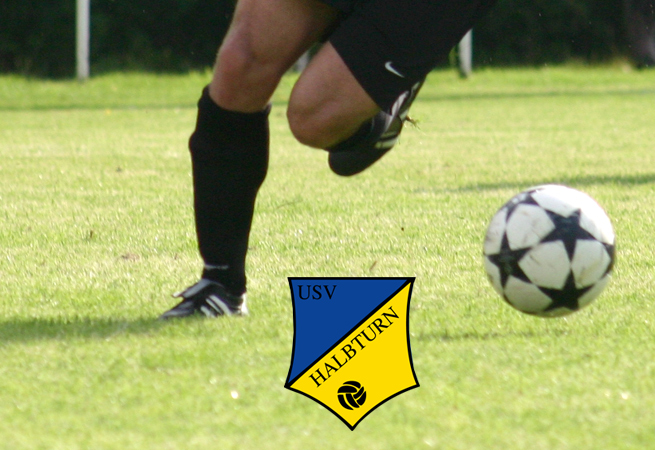 Fußballer-Beine mit USV Logo und Fußball am Fußballplatz